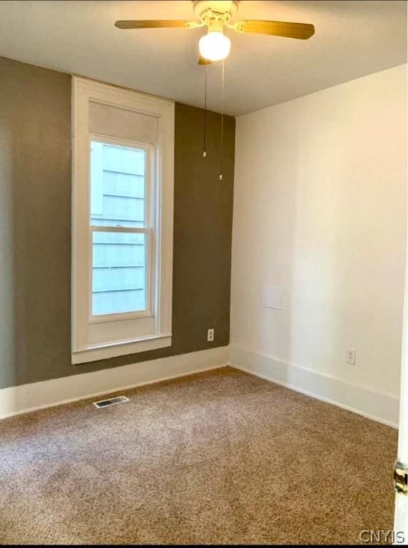 carpeted spare room featuring ceiling fan