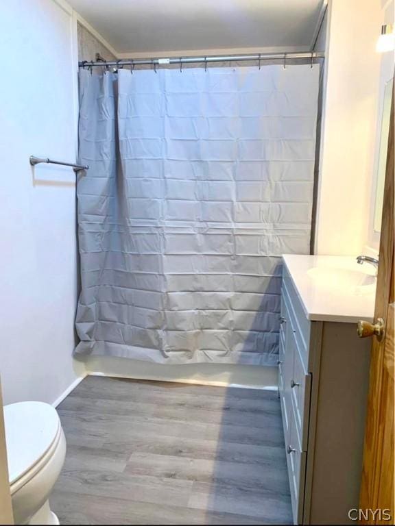 full bathroom with vanity, hardwood / wood-style floors, shower / bath combo, and toilet