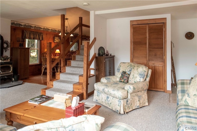 carpeted living room featuring a wood stove and vaulted ceiling