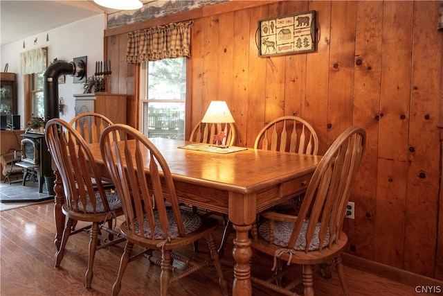 dining room featuring hardwood / wood-style flooring and wooden walls