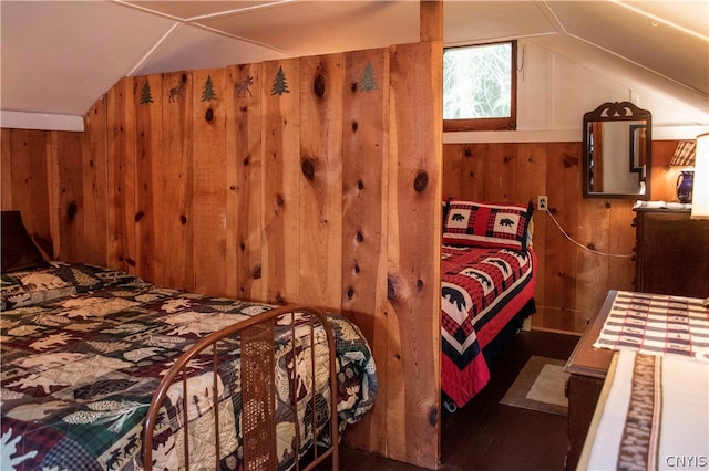 bedroom featuring wooden walls and vaulted ceiling