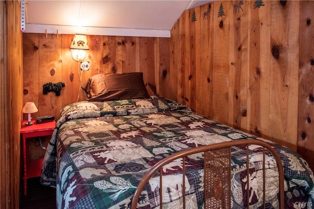 bedroom with wood walls and vaulted ceiling