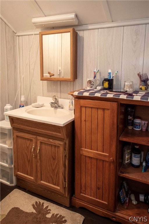 bathroom featuring vanity and wood walls