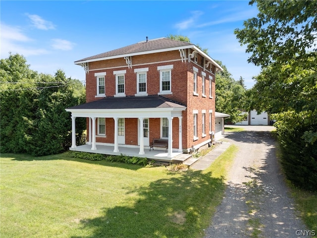 italianate-style house featuring a garage, covered porch, an outbuilding, and a front yard