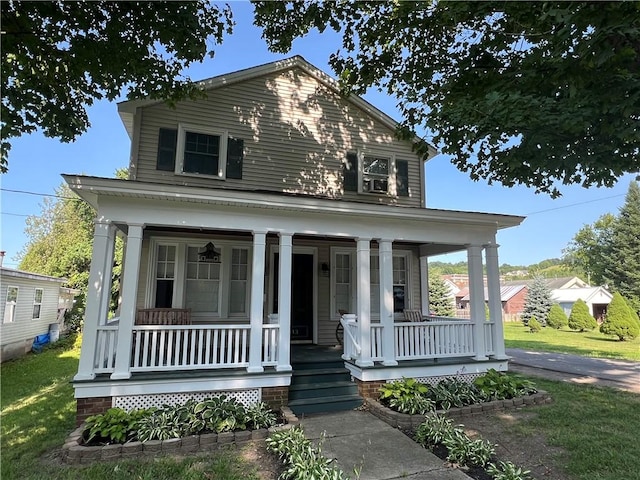 view of front facade featuring a front yard and covered porch