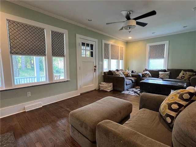 living area with visible vents, wood finished floors, baseboards, and ornamental molding