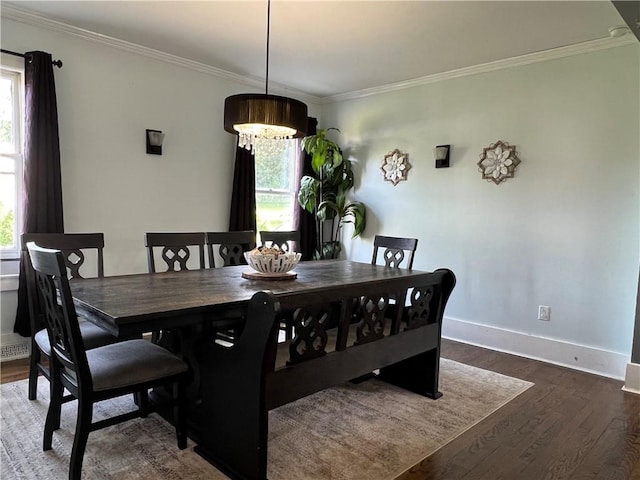 dining space featuring an inviting chandelier, wood finished floors, baseboards, and ornamental molding