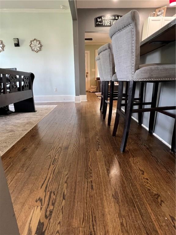 dining area with crown molding, baseboards, and wood finished floors