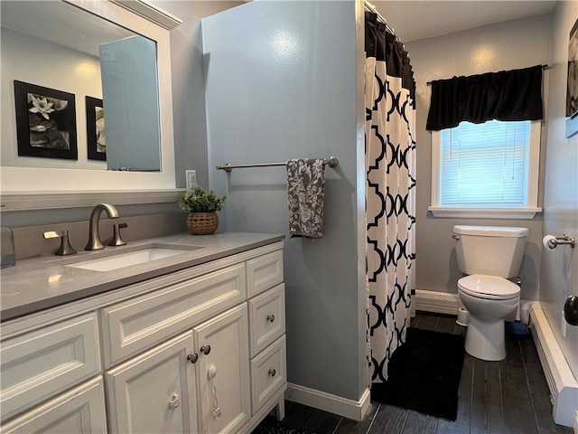 bathroom with vanity, wood finished floors, baseboards, toilet, and baseboard heating