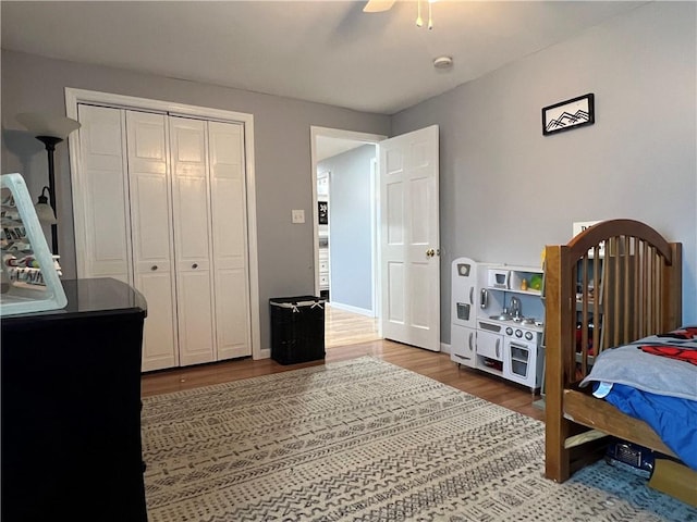 bedroom with a closet, baseboards, ceiling fan, and wood finished floors