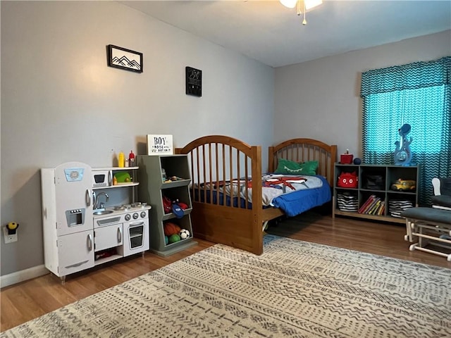 bedroom featuring a ceiling fan, wood finished floors, and baseboards