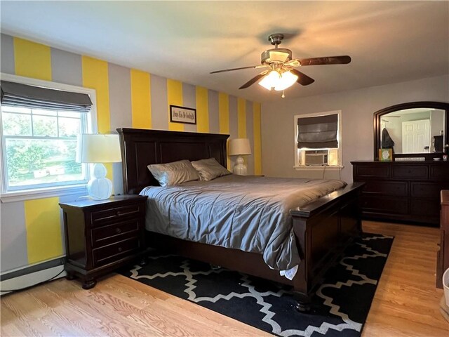 bedroom featuring cooling unit, a baseboard radiator, wallpapered walls, light wood-style flooring, and ceiling fan