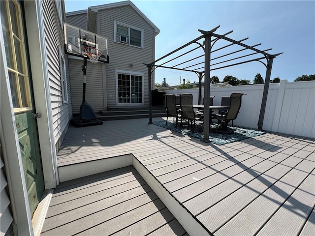 wooden deck featuring outdoor dining space, a pergola, and fence