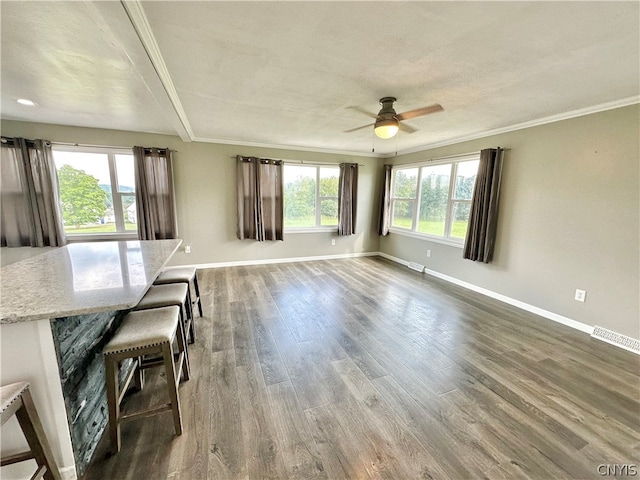 unfurnished dining area with a textured ceiling, dark hardwood / wood-style floors, ceiling fan, and ornamental molding