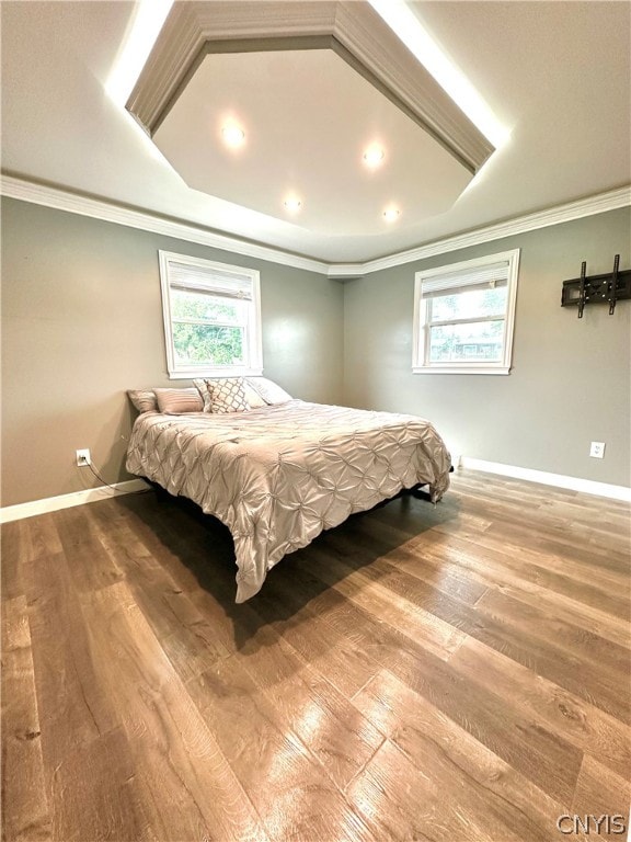 bedroom featuring hardwood / wood-style floors, multiple windows, and crown molding