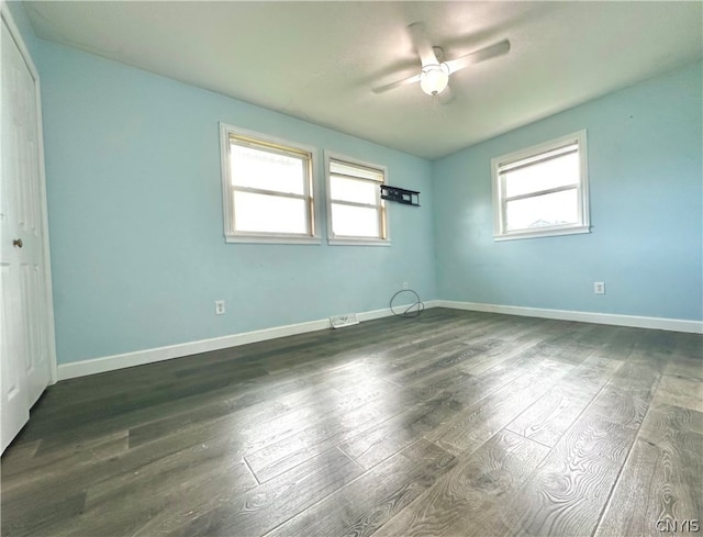 unfurnished room with ceiling fan and dark wood-type flooring