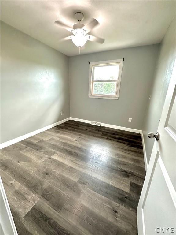 empty room featuring ceiling fan and dark hardwood / wood-style flooring