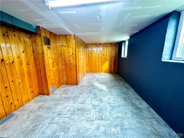 basement featuring a healthy amount of sunlight and wooden walls