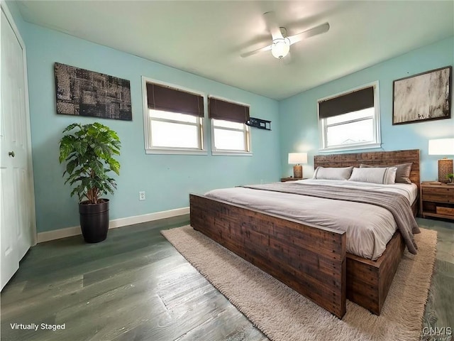 bedroom with ceiling fan, a closet, dark hardwood / wood-style flooring, and multiple windows