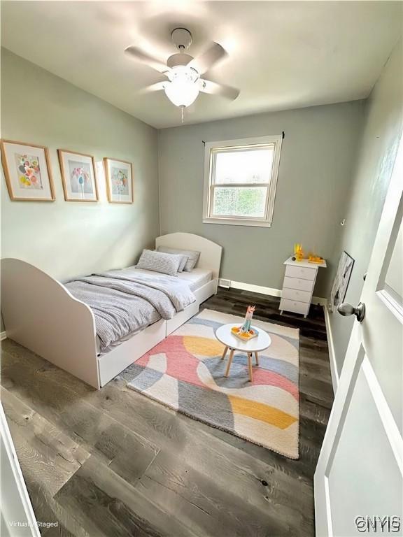 bedroom with dark hardwood / wood-style floors and ceiling fan