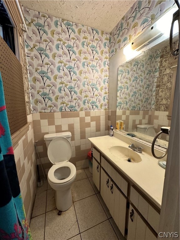 bathroom featuring tile walls, tile patterned floors, vanity, and toilet