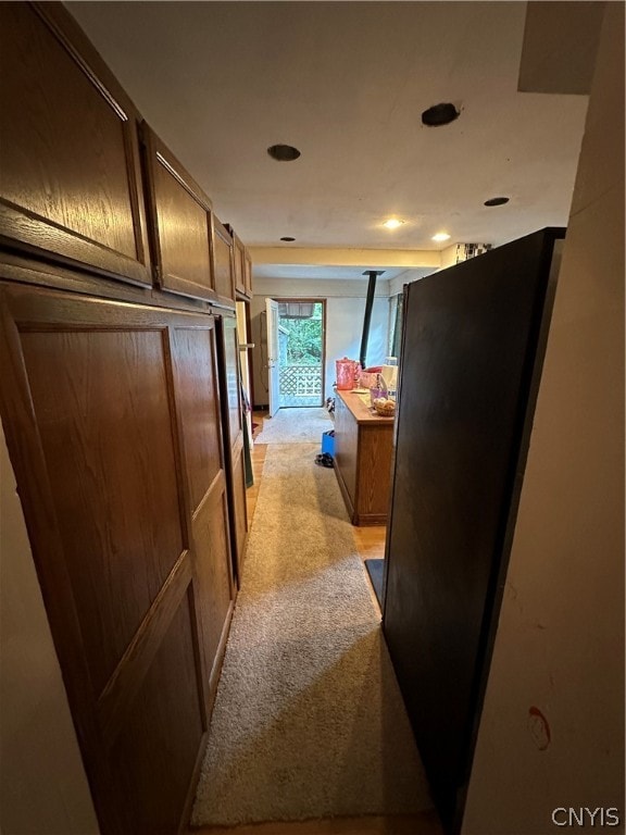 corridor featuring light colored carpet