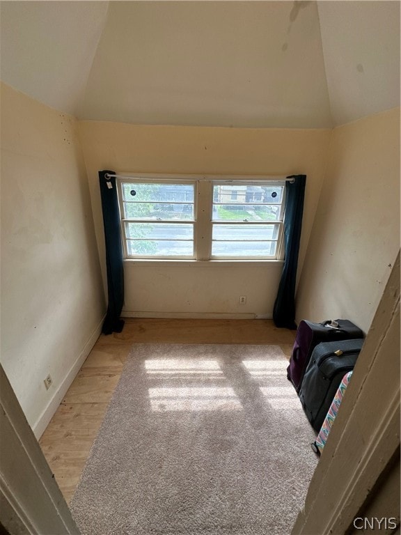 unfurnished room featuring light hardwood / wood-style flooring and lofted ceiling