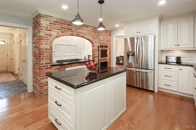 kitchen with decorative light fixtures, tasteful backsplash, a kitchen island, light hardwood / wood-style floors, and appliances with stainless steel finishes