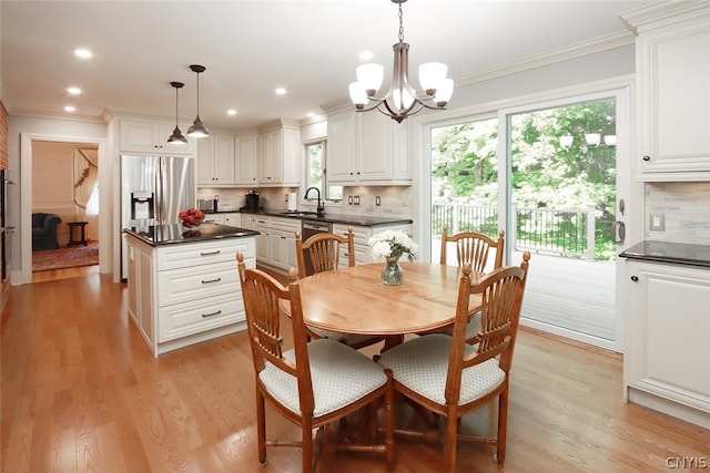 dining space featuring light hardwood / wood-style floors, sink, a notable chandelier, and plenty of natural light