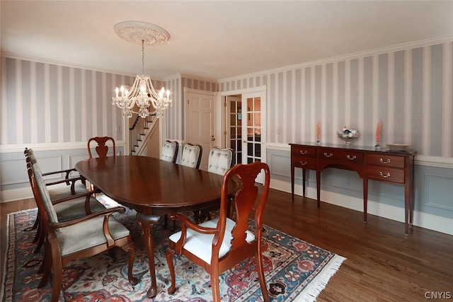 dining area with a notable chandelier, ornamental molding, and hardwood / wood-style floors