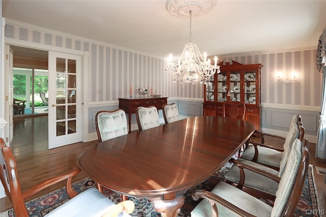 dining area with an inviting chandelier, wood-type flooring, french doors, and crown molding