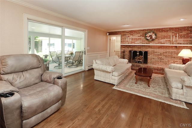 living room with crown molding, baseboard heating, a brick fireplace, brick wall, and wood-type flooring