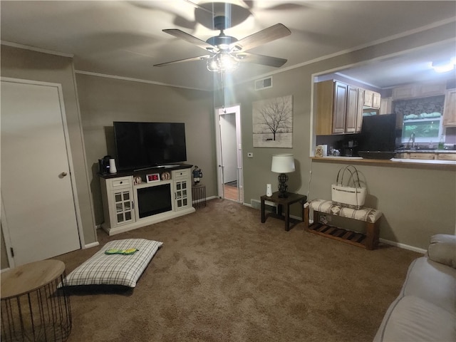 carpeted living room with crown molding, sink, and ceiling fan