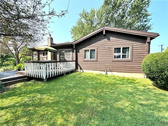 back of house featuring a yard and a deck