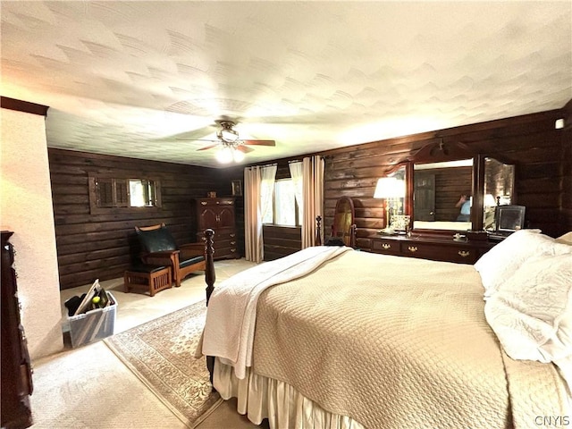 bedroom with ceiling fan, light colored carpet, rustic walls, and a textured ceiling