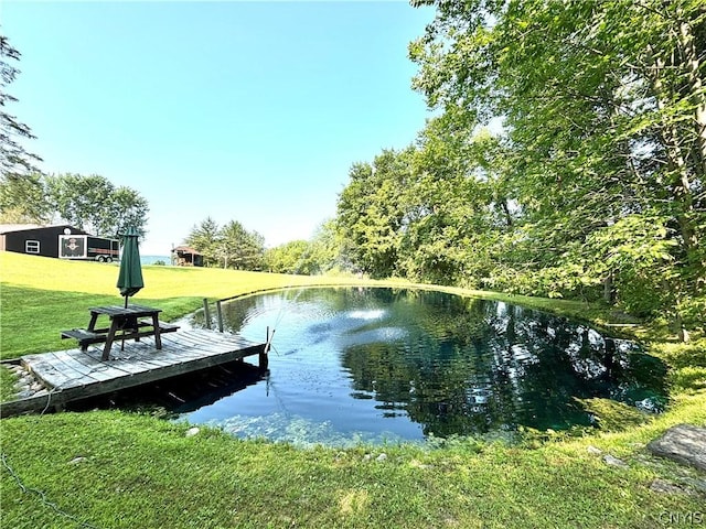 view of dock featuring a water view and a lawn