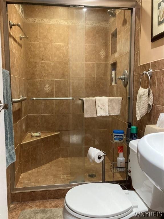 full bath featuring tile walls, toilet, and a stall shower