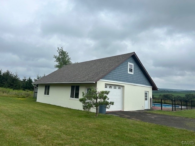 exterior space with a garage and a lawn