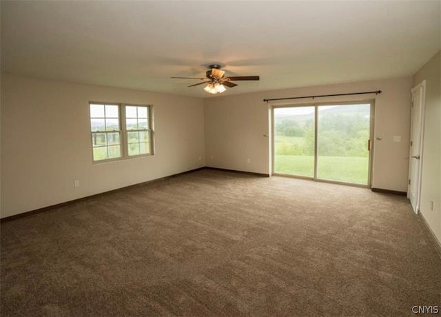 carpeted spare room featuring ceiling fan