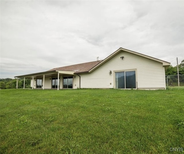 rear view of property with a lawn