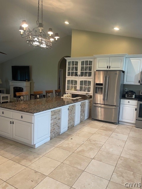 kitchen featuring stainless steel fridge with ice dispenser, lofted ceiling, light tile patterned floors, and white cabinets