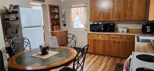 kitchen featuring white appliances, sink, and light hardwood / wood-style flooring