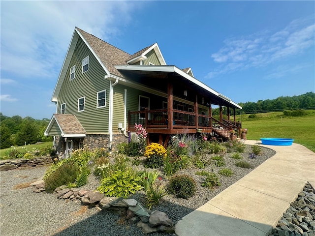 rear view of property with covered porch and a yard