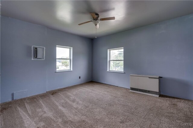 unfurnished room with plenty of natural light, carpet, and ceiling fan