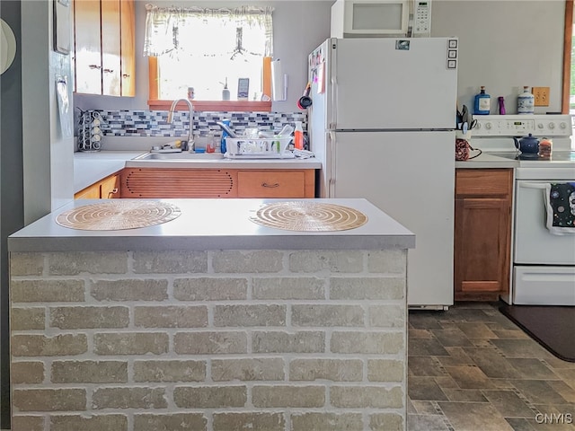 kitchen featuring sink, dark tile patterned flooring, tasteful backsplash, and white appliances