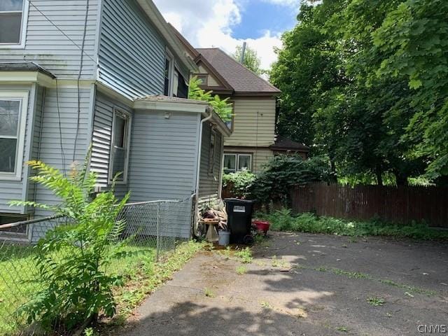 view of property exterior with a patio and fence