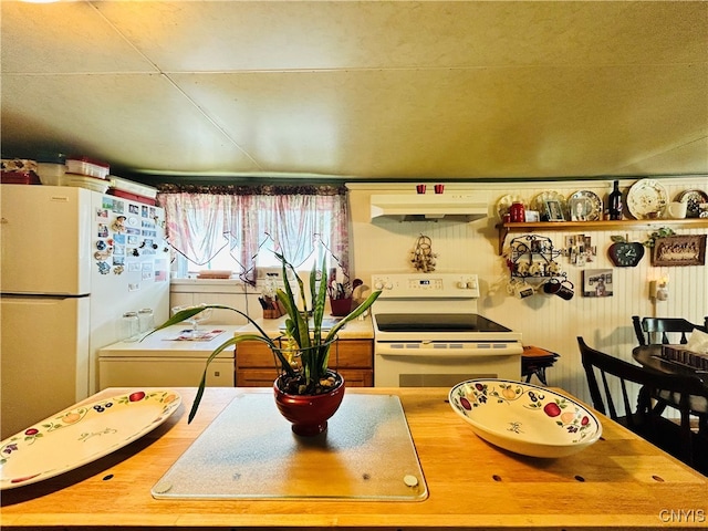 kitchen with exhaust hood and white appliances