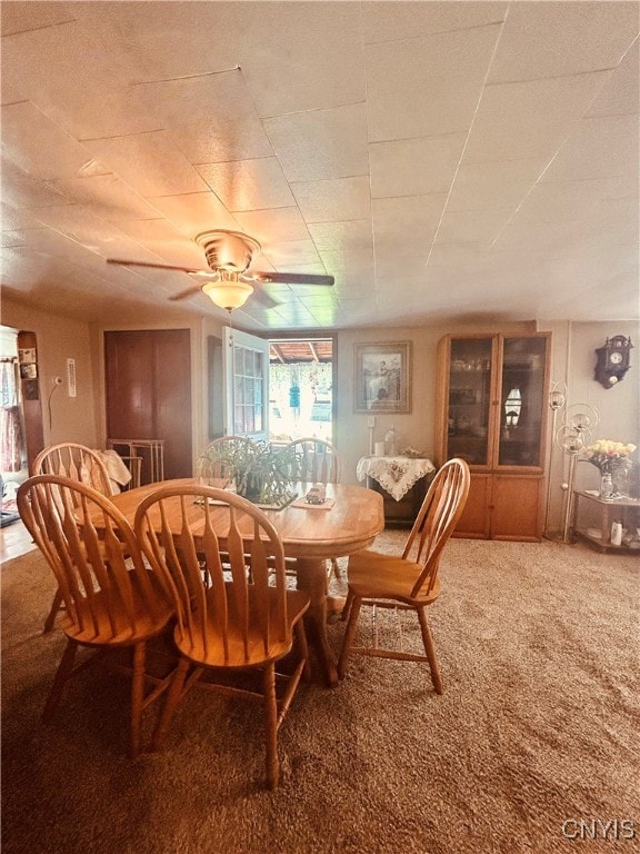 carpeted dining space featuring ceiling fan