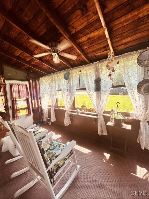 sunroom featuring wood ceiling, lofted ceiling with beams, and ceiling fan