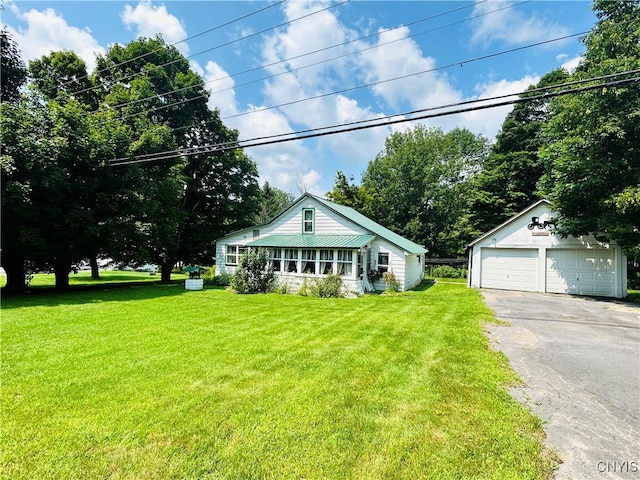 view of front facade featuring a garage, an outbuilding, and a front yard